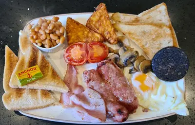 a plate of breakfast food with eggs bacon and toast at The Pavilion Guest House in Millom