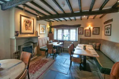 a restaurant with tables and chairs and a fireplace at The Fleece Inn in Shireshead
