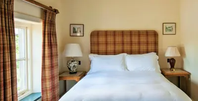 a bedroom with a bed and two lamps and a window at The Fleece Inn in Shireshead