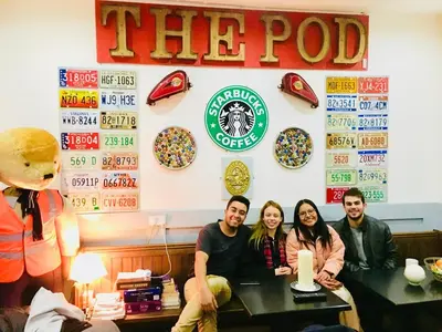 a group of people sitting at a table in a restaurant at The Liverpool Pod Travel Hostel in Liverpool