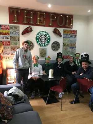 a group of people sitting around a table in a room at The Liverpool Pod Travel Hostel in Liverpool
