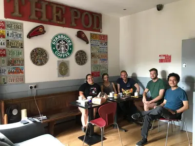 a group of people sitting at a table in a restaurant at The Liverpool Pod Travel Hostel in Liverpool