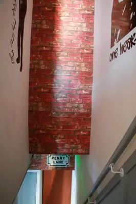 a brick wall next to a stairway with a sign on it at The Liverpool Pod Travel Hostel in Liverpool