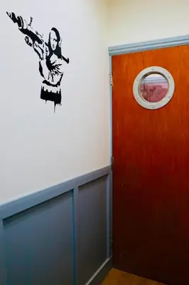 a door with a painting of a woman on the wall at The Liverpool Pod Travel Hostel in Liverpool