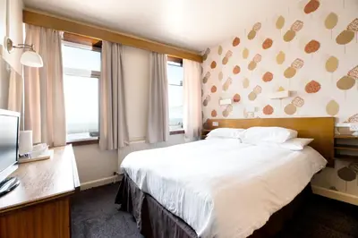 a hotel room with a bed and two windows at The Headlands in Blackpool