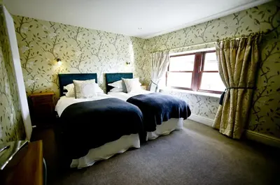 a bedroom with two beds and a window at The Shireburn Arms in Clitheroe