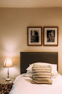 a bedroom with a bed with a lamp and pictures on the wall at The Shireburn Arms in Clitheroe