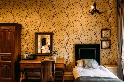 a bedroom with a bed and a desk and a mirror at The Shireburn Arms in Clitheroe