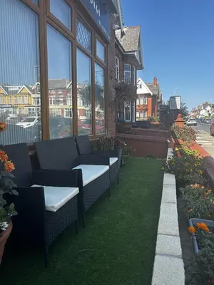 a patio with benches and grass in front of a building at The Inglewood Hotel *Adults Only* in Blackpool