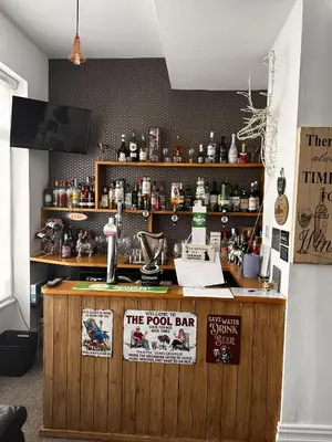 a bar with posters on the wall of a room at The Inglewood Hotel *Adults Only* in Blackpool