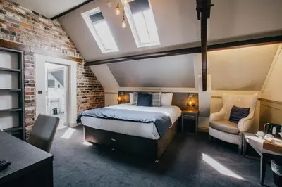 a bedroom with a bed and a brick wall at The Duke of Edinburgh Hotel & Bar in Barrow in Furness