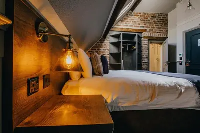 a bedroom with a bed and a wooden table at The Duke of Edinburgh Hotel & Bar in Barrow in Furness