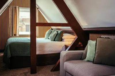 a bedroom with a bed and a couch and a chair at The Duke of Edinburgh Hotel & Bar in Barrow in Furness