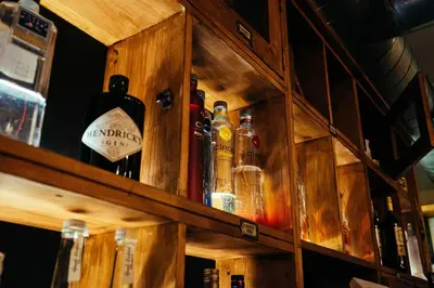 a wooden shelf with bottles of alcohol on it at The Duke of Edinburgh Hotel & Bar in Barrow in Furness