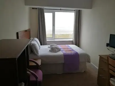 a hotel room with a bed and a window at Westleigh B&B in Morecambe
