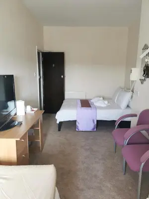 a hotel room with a bed and a desk and chairs at Westleigh B&B in Morecambe