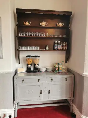 a white dresser in a corner of a room at Westleigh B&B in Morecambe