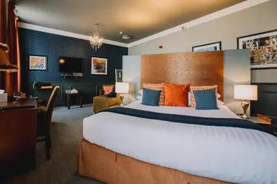 a hotel room with a large bed and a desk at The Sun Hotel & Bar in Lancaster