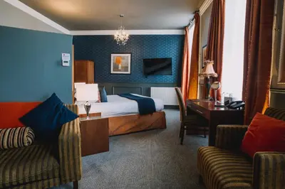 a hotel room with a bed and a desk at The Sun Hotel & Bar in Lancaster