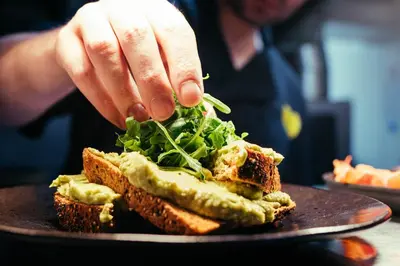 a person is making a sandwich on a plate at The Sun Hotel & Bar in Lancaster