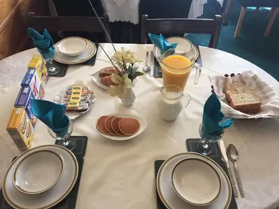 a table with plates of food and drinks on it at Fortuna House Hotel in Blackpool