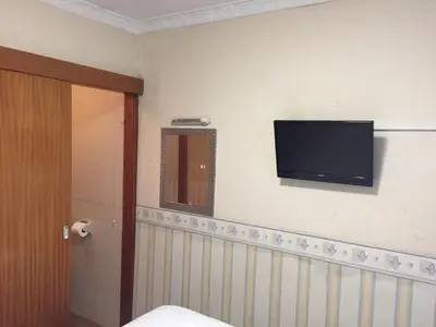 a bathroom with a flat screen tv on the wall at Fortuna House Hotel in Blackpool