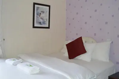a bedroom with a bed with white sheets and pillows at Fortuna House Hotel in Blackpool