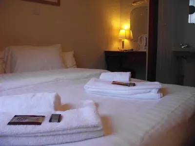 a hotel room with white towels on a bed at Fortuna House Hotel in Blackpool