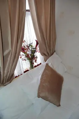 a bed with a pillow on it with a window at Fortuna House Hotel in Blackpool