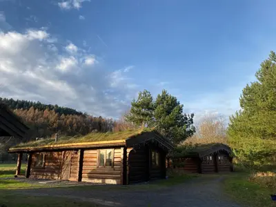 a log cabin with a grass roof on it at Log home village in Ulverston