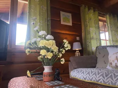 a living room with a vase of flowers on a table at Log home village in Ulverston