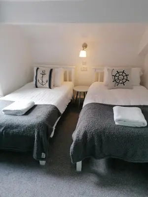 a bedroom with two beds and a table in it at Edendale House in Southport