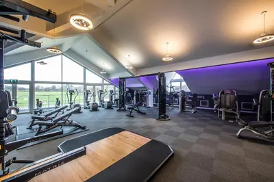 a gym with a bunch of treadmills and machines at Formby Hall Golf Resort & Spa in Southport