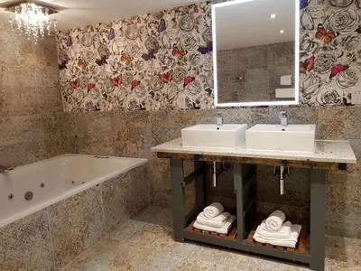 a bathroom with two sinks and a tub and a mirror at Lymestone Boutique Accommodation in Grange Over Sands