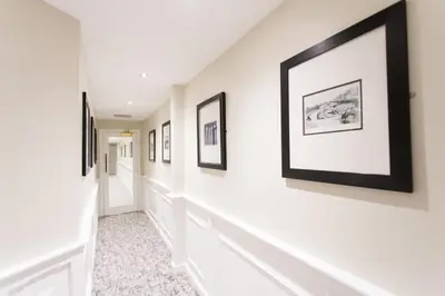 a hallway with framed art on the walls at Doric Hotel in Blackpool