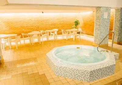 a hot tub in a room with tables and chairs at Doric Hotel in Blackpool