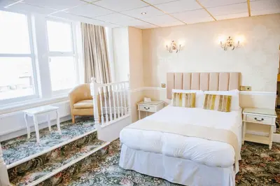a hotel room with a bed and a chair at Doric Hotel in Blackpool