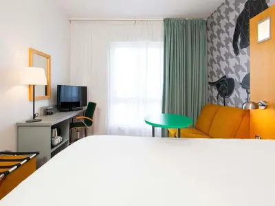 a hotel room with a bed and a couch and a table at ibis Styles Haydock in Haydock