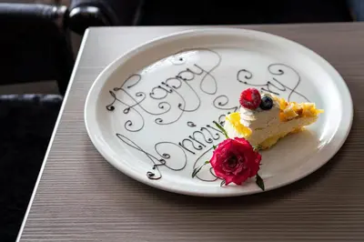 a piece of cake on a plate with the words happy birthday at The Lord Street Hotel; BW Signature Collection in Southport