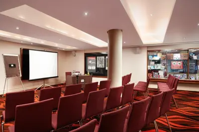a conference room with chairs and a screen at Hard Days Night Hotel Liverpool in Liverpool