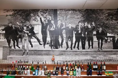 a group of people jumping in front of a mural at Hard Days Night Hotel Liverpool in Liverpool