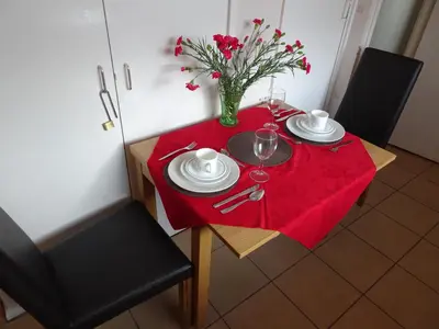 a table with a red table cloth and a vase of flowers at Home with a view in Liverpool