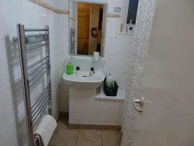 a white bathroom with a sink and a mirror at Home with a view in Liverpool