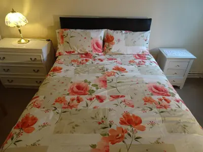 a bedroom with a bed with a floral bedspread at Home with a view in Liverpool