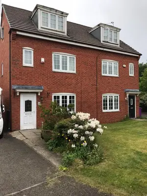 a red brick house with a white door and some flowers at In Our Liverpool Home Sleeps 5 in 2 Double & 1 Single Bedrooms in Liverpool