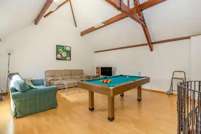 a living room with a pool table and a couch at Southport Coach House in Southport