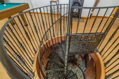 a spiral staircase with a metal railing at Southport Coach House in Southport