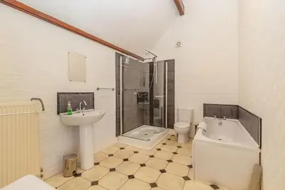 a bathroom with a sink and a tub and a toilet at Southport Coach House in Southport