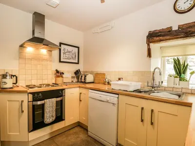 a kitchen with a sink and a stove top oven at Lane Head in Grange Over Sands