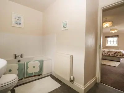 a bathroom with a toilet and a bath tub at Lane Head in Grange Over Sands